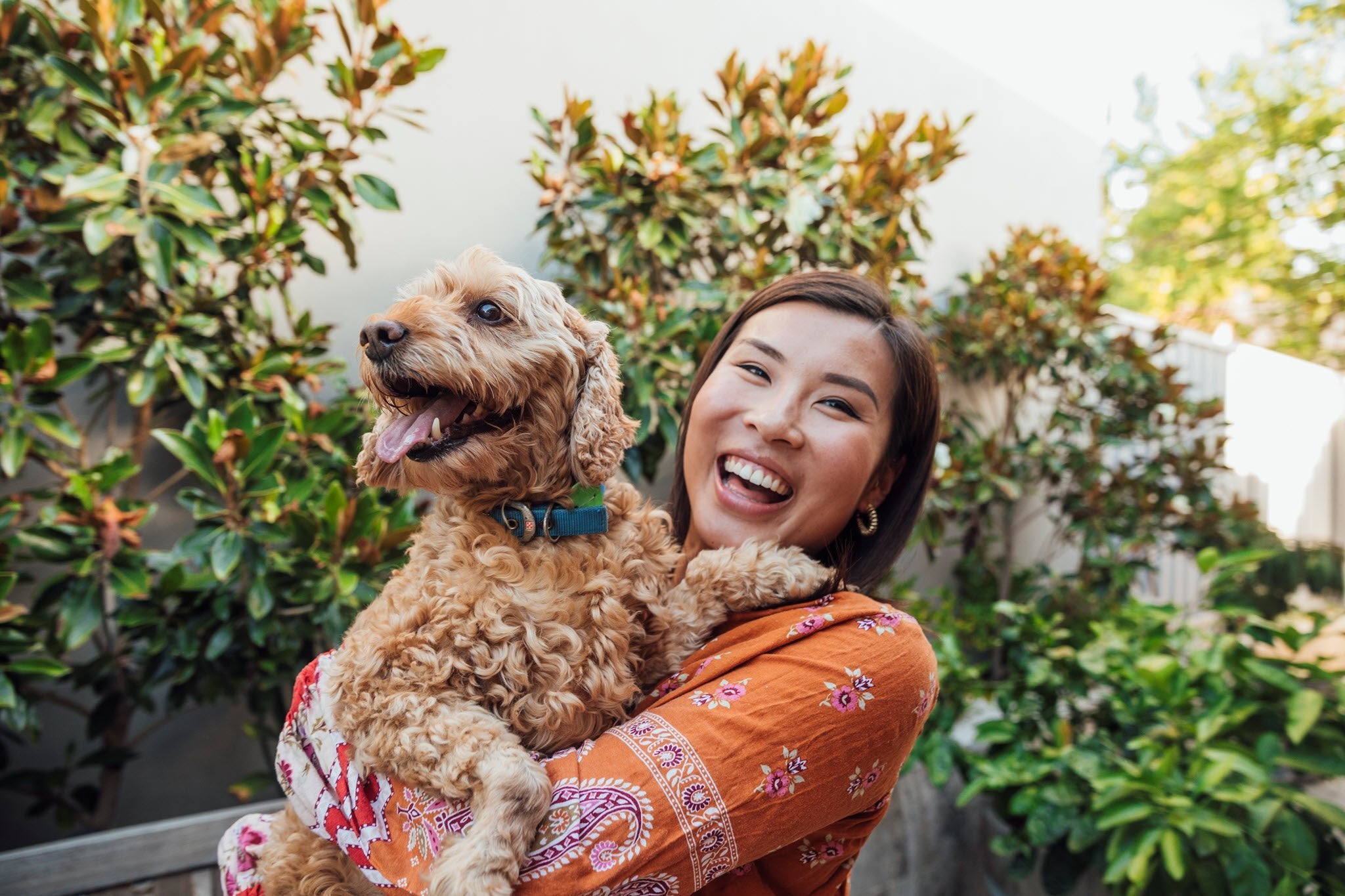 A woman holding a happy dog